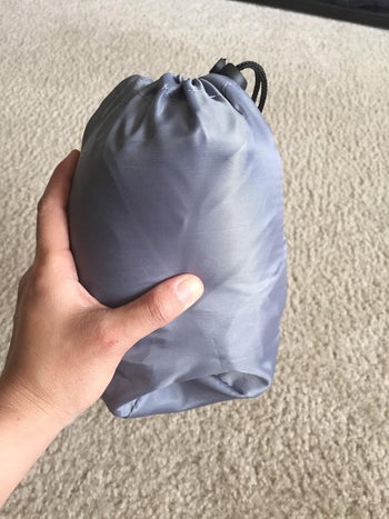 reviewer showing how small the pillow is when it's not inflated