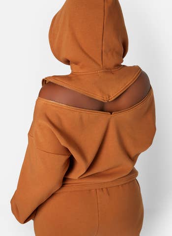 model showing the back of the sweatshirt with the v-shaped zippered opening