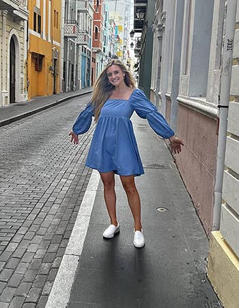 a reviewer wearing the balloon sleeve dress in blue 