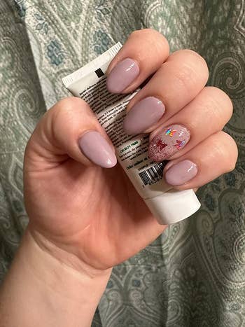 reviewer showing off mauve gel mani with holographic butterflies