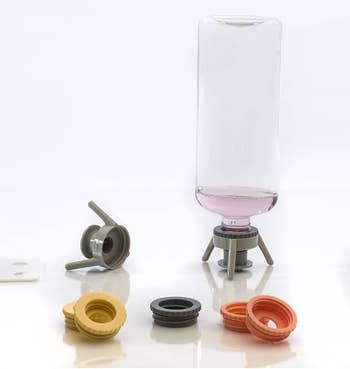 the bottle emptying kit, with one of the adapters holding an upside down soap bottle