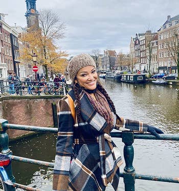 reviewer wearing the plaid coat on bridge in Amsterdam