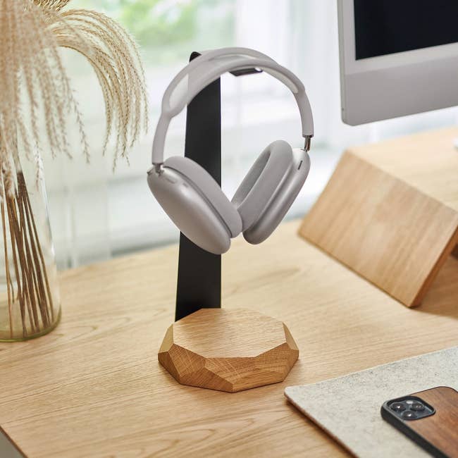 Headphones on a wooden stand on a desk