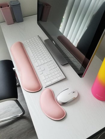 reviewer pic the pink memory foam wrist rests set up at a desk with a keyboard and mouse
