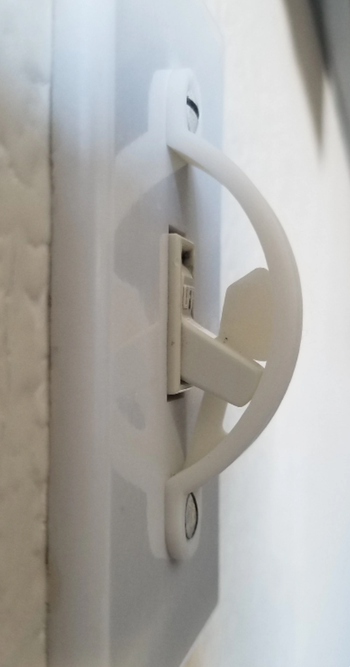A curved blocker screwed into the lightswitch panel with a plastic compontent to stop the switch from going down 