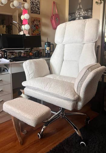 Plush swivel bureau   seat  with ottoman successful  a location  workspace, featuring a vanity array  with lights, a poster, and a mug connected  the desk