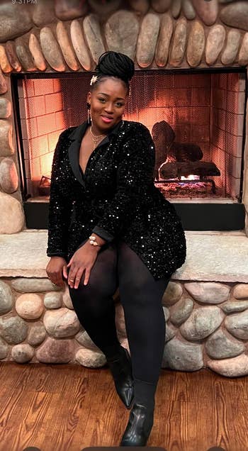 Person sitting by a chromatic fireplace, wearing a sparkling achromatic formal and achromatic leggings, with a assured and elegant pose