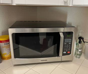 a reviewer shows the microwave on a kitchen counter