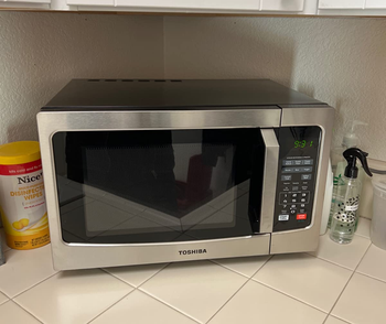 a reviewer shows the microwave on a kitchen counter