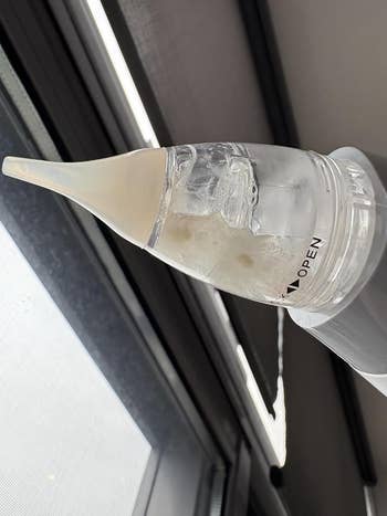 Nasal spray instrumentality angled adjacent a window, highlighting the