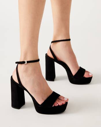 model in black platform sandals with a chunky heel and ankle strap