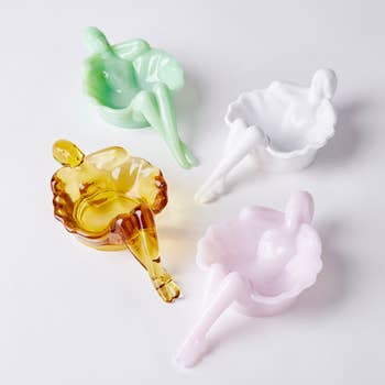 four glass dishes that look like a bathing woman
