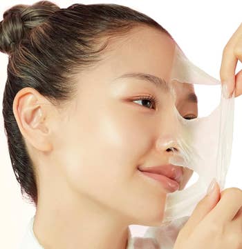 Woman peeling disconnected  a facial mask, showcasing creaseless  skin