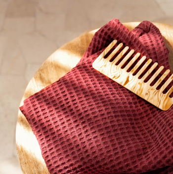 the waffle towel in the color sumac with a comb sitting on top of it