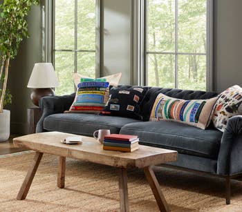 Cozy surviving  country   with a grey  sofa adorned with colorful decorative pillows, woody  java  table, and ample  window