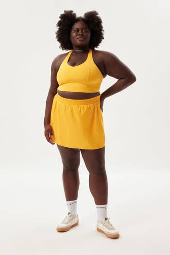 a model in a yellow cami and skort