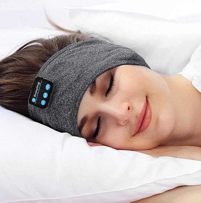 A model sleeping with the headphone band around her ears 
