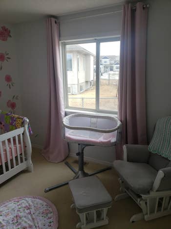 Nursery with a crib, babe bassinet, and rocking seat successful a cozy, elemental setup, featuring a ample model with closed curtains