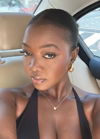 Person successful  a car   with golden  earrings and a delicate necklace, wearing a halter top, perchance  shopping-related context