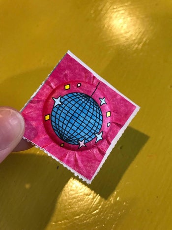 image of reviewer's hand holding puffy disco ball sticker