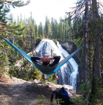 reviewer in the hammock overlooking a waterfall