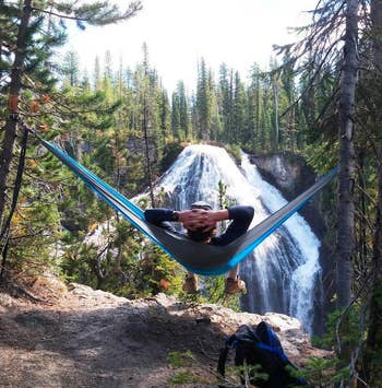 reviewer in the hammock overlooking a waterfall