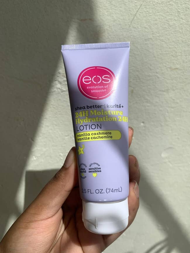 Person holding a tube of eos 24H Moisture Lotion, vanilla cashmere scent