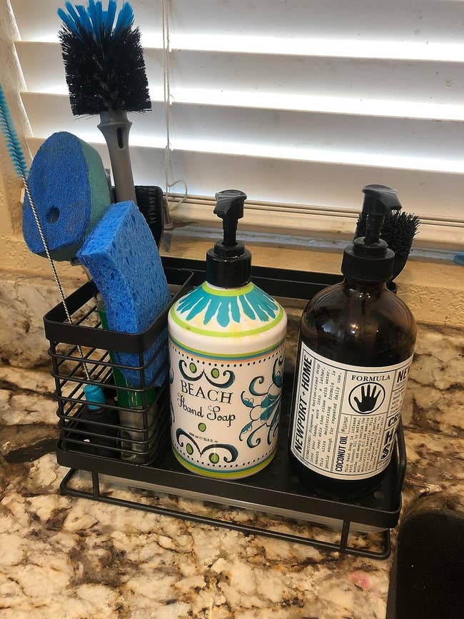reviewer image of the black kitchen sink organizer with soap and sponge on it
