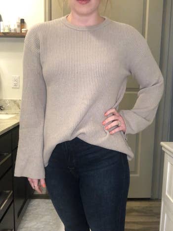 a reviewer wearing the sweater with jeans