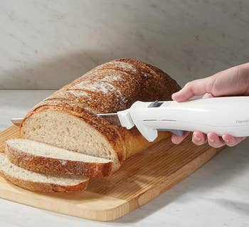 Model using white handled knife on bread loaf 