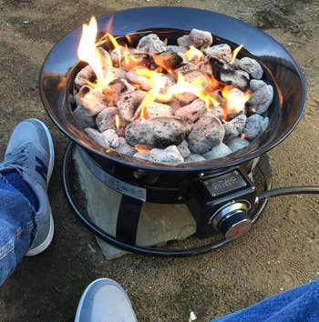 Reviewer sitting next to black fire pit