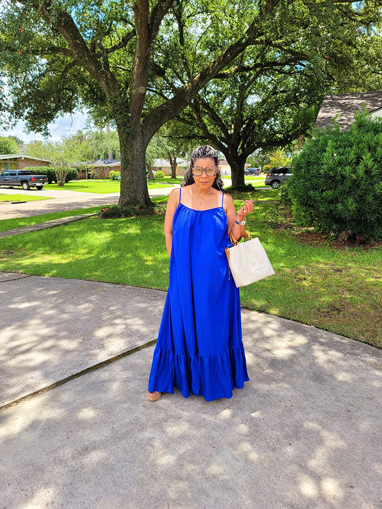 Person successful  a flowing summertime  formal  holds a beige tote bag, lasting  connected  a driveway. 