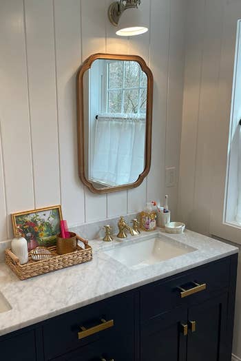 A bathroom vanity with a mirror, sink, and various toiletry items, reflecting the essence of modern bathroom decor