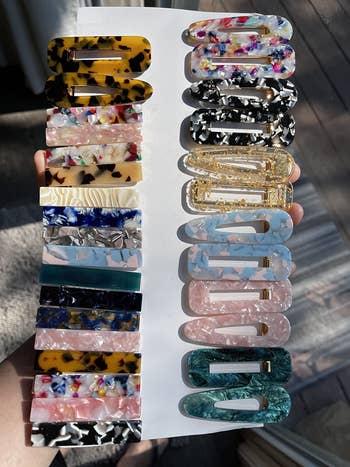 reviewer holding the pack of assorted barrettes