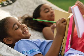 A child model writing with the green pencil