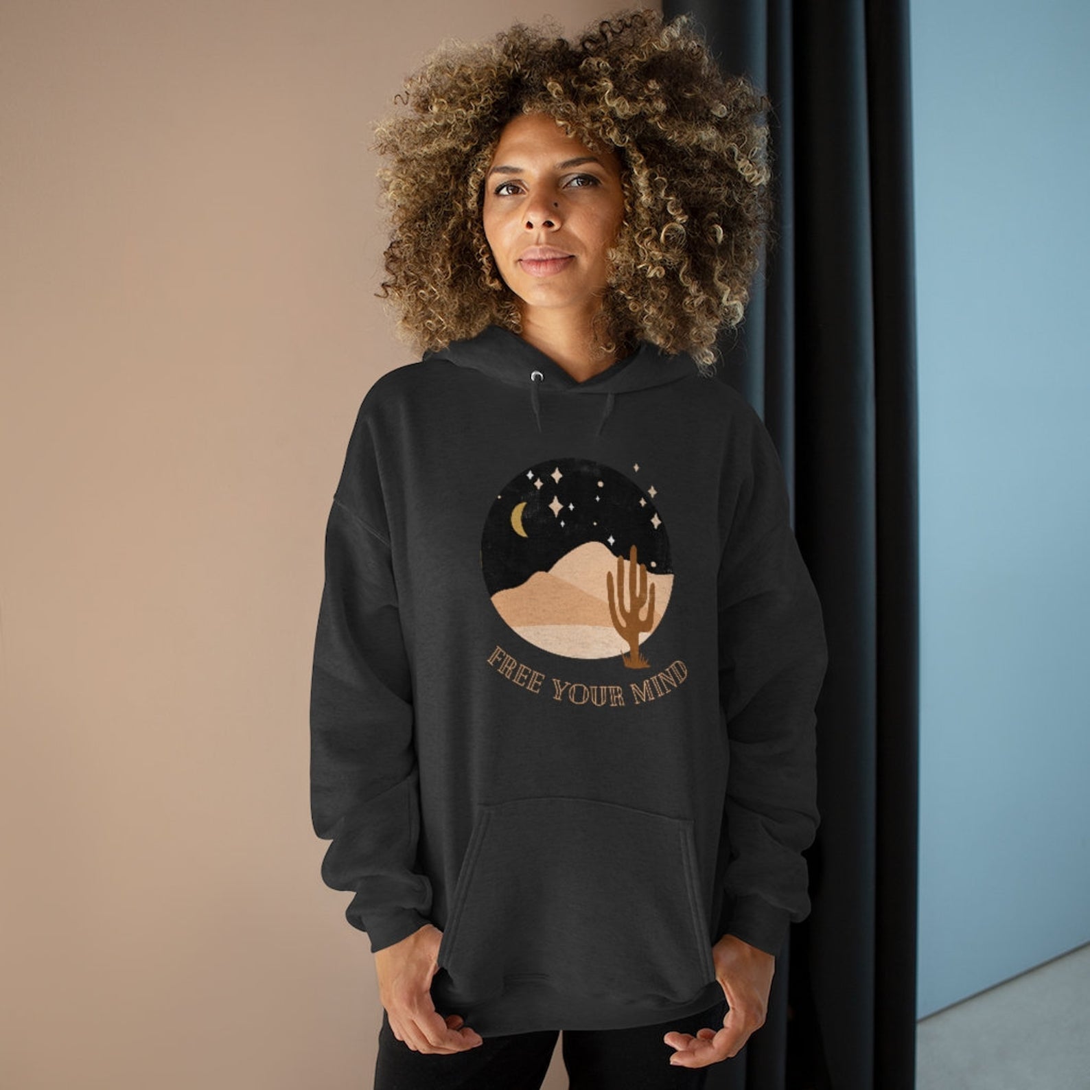model wearing a black hoodie that says free your mind with a circle graphic of a desert