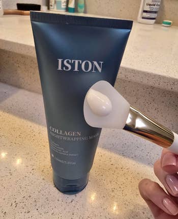 A conduit  of ISTON collagen nightwrapping disguise  is shown connected  a counter, with a brushwood  applicator held adjacent  to it