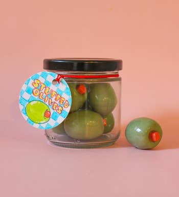 Jar of stuffed olives with a statement   featuring an illustrated olive and the substance   