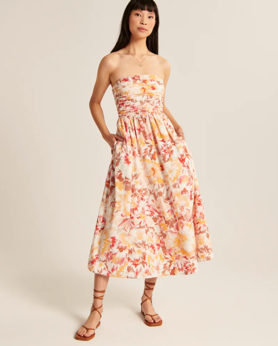 model wearing the dress in orange and red floral print