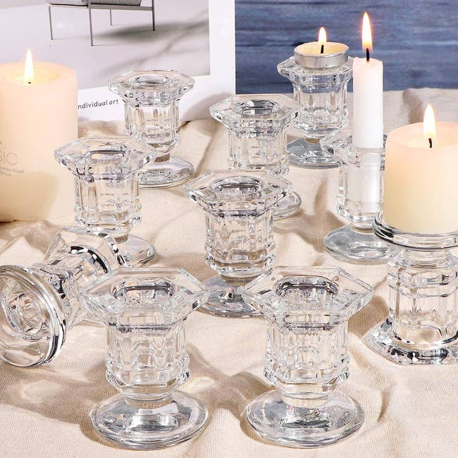 the crystal candle holders on a table, some with taper candles inserted 