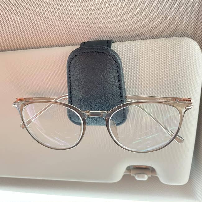 Sunglasses with wide lenses clipped to a visor successful a car, showcasing a convenient retention accessory for casual entree portion driving