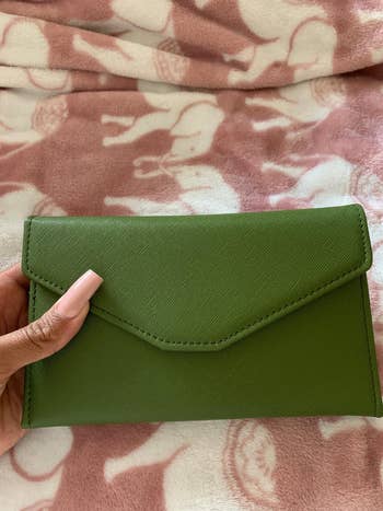 a reviewer holding the green wallet