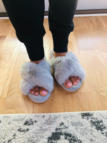 a reviewer wearing the slippers in grey