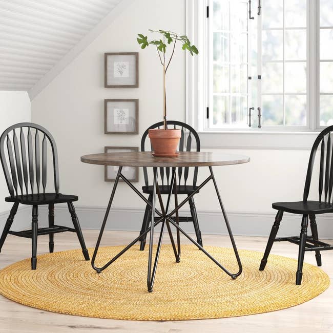 the dining table with black iron legs and a dark wood surface