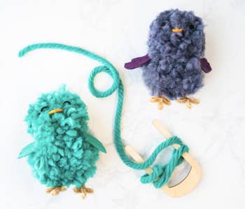 teal yarn wrapping around the spool with two of the owls
