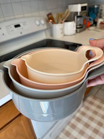 a reviewer holding the stacked mixing bowls