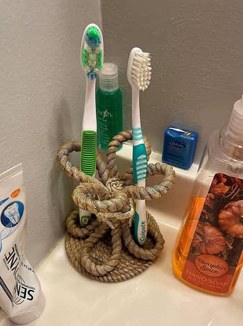 reviewer image of toothbrushes in the rope braid toothbrush holder