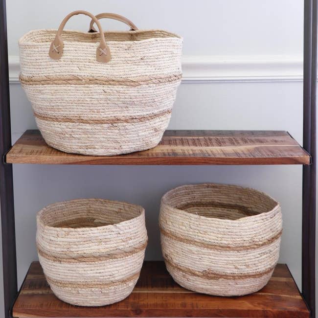 three natural maize baskets on shelves