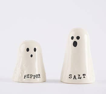two ghost shaped salt and pepper holders. the smaller one says pepper and the larger says salt.