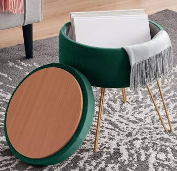 The green ottoman with the top off to show storage space inside